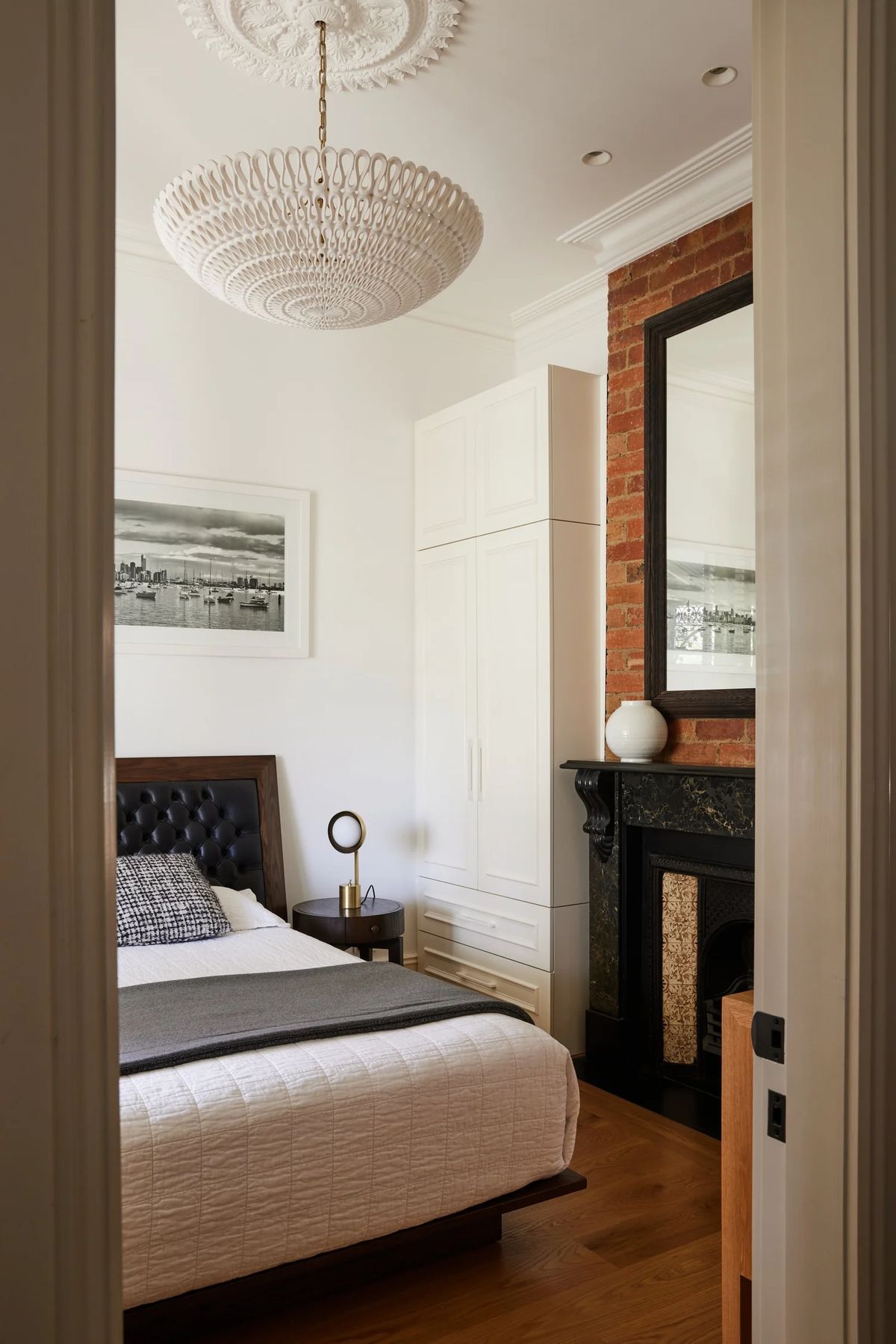 Styled bedroom with a marble fireplace and built-in robes