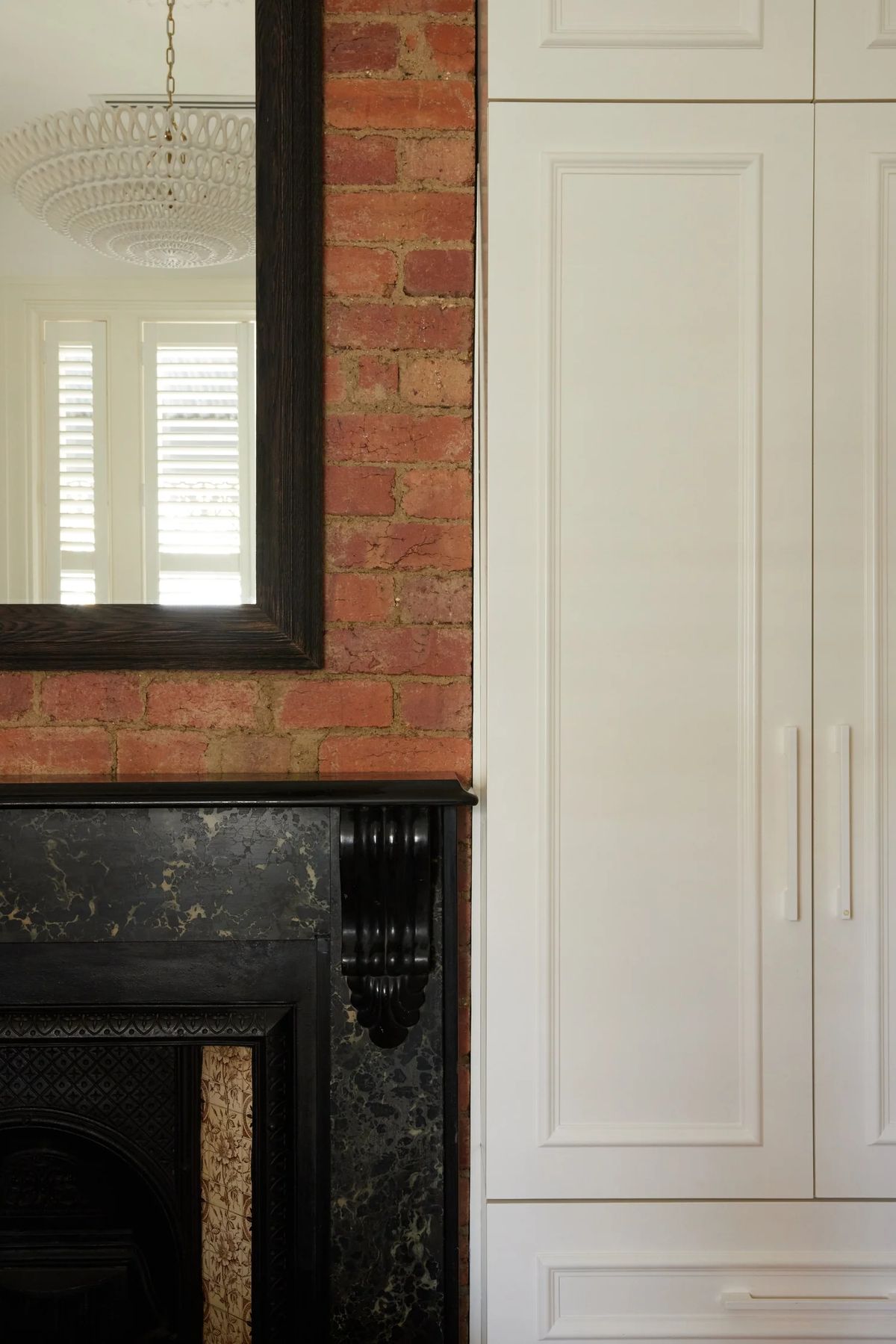 Black marble mantel against exposed brick