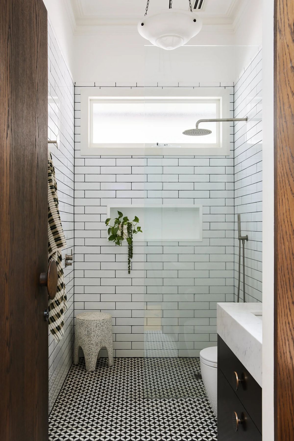 White subway-tiled shower with a niche