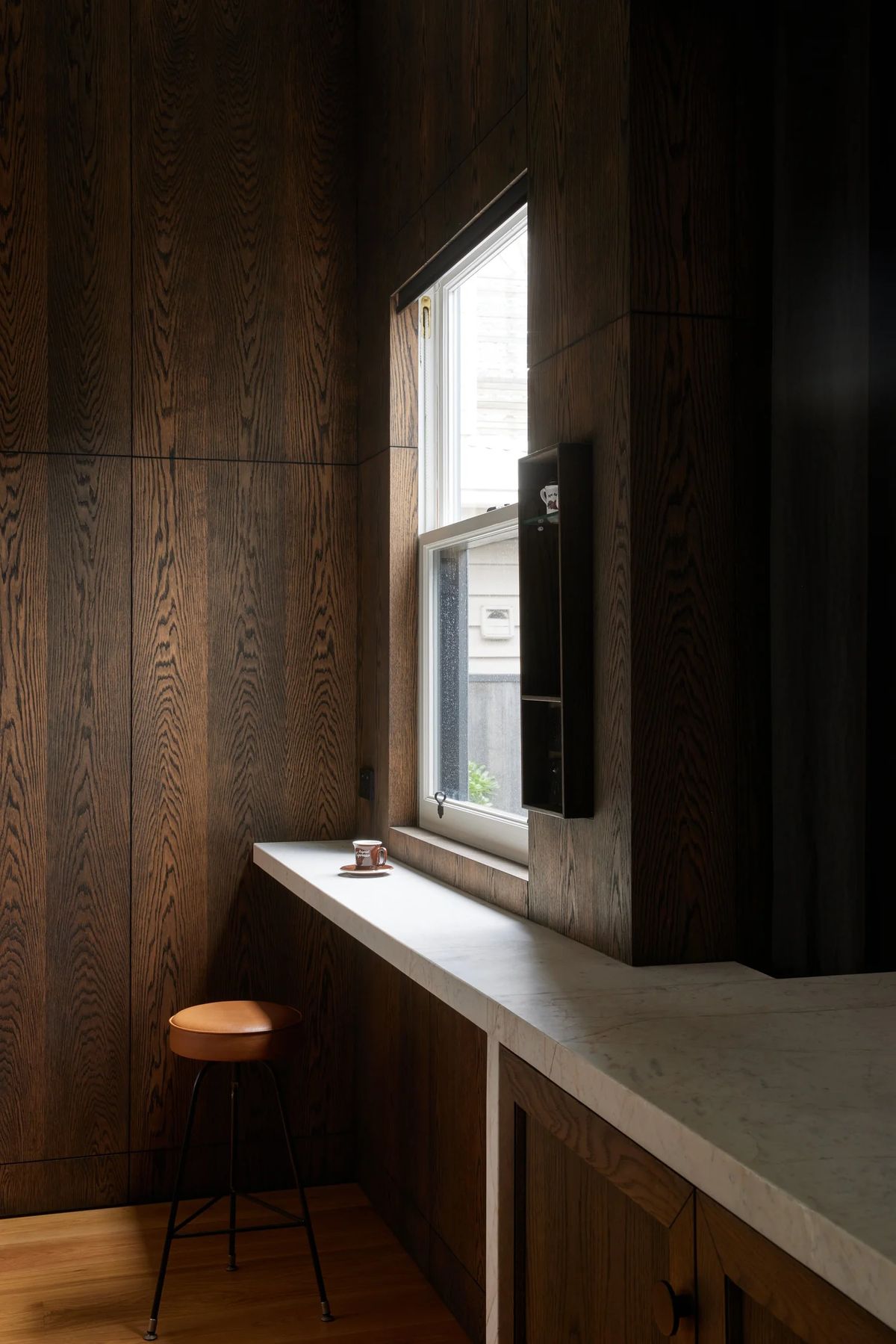 Timber-lined window nook with a stone bench