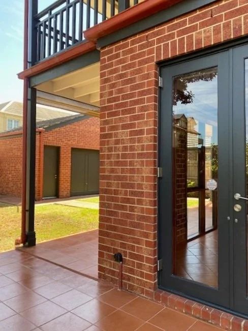 Brick home exterior with freshly painted trims and a new black door
