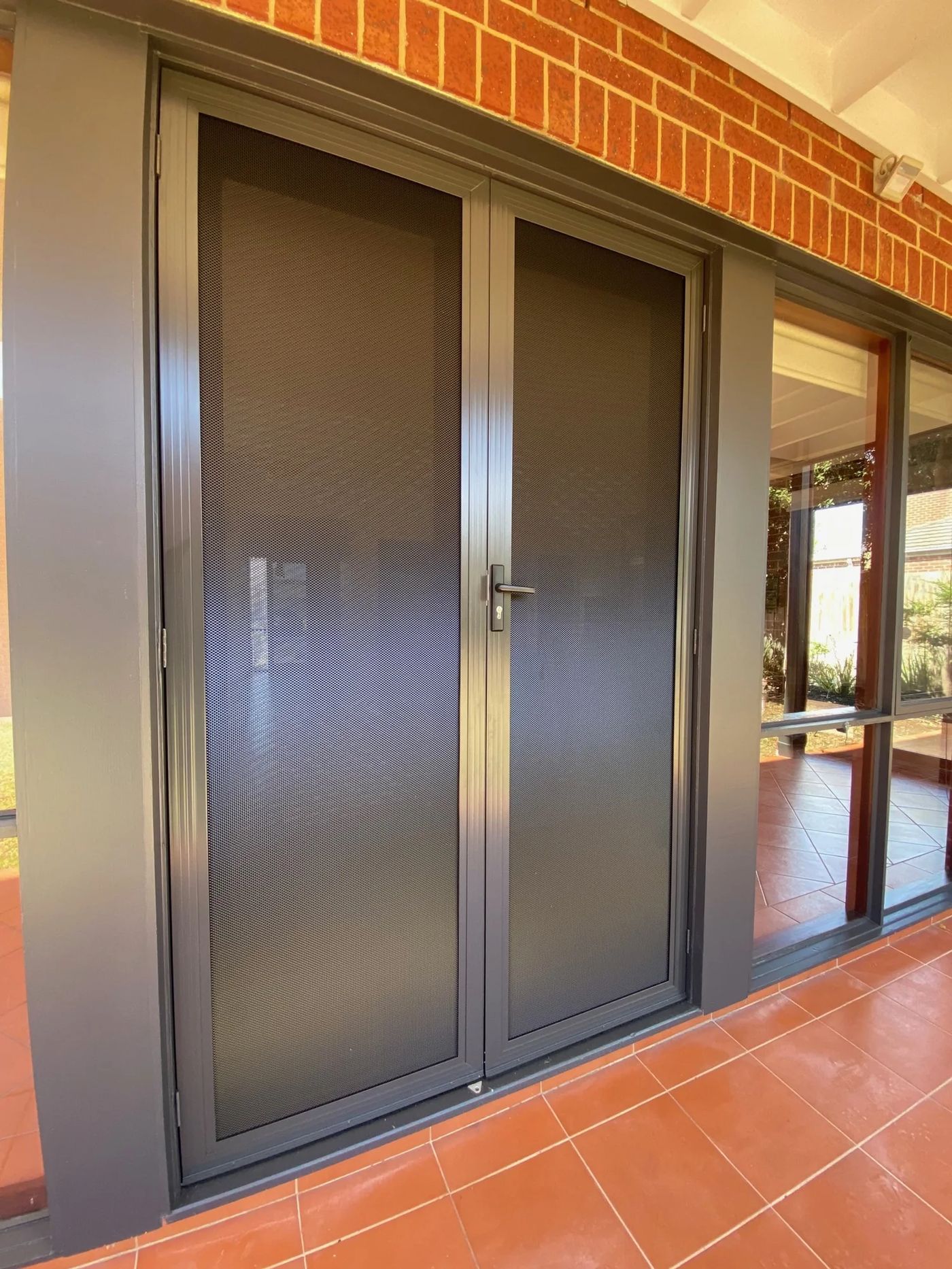 New black security doors on a freshly painted entry